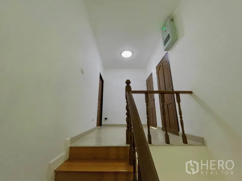 Detached House for rent in Suan Luang, Bangkok - Upper landing with wooden doors to bedrooms and soft ceiling light.