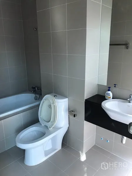 Townhouse for rent in Suan Luang, Bangkok - Bathroom with bathtub, toilet and vanity in light gray tile.