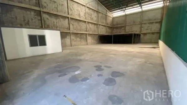 货栈 出租在Prawet, Bangkok - 开放式仓库空间，高金属屋顶与混凝土地坪，后方设有夹层平台。