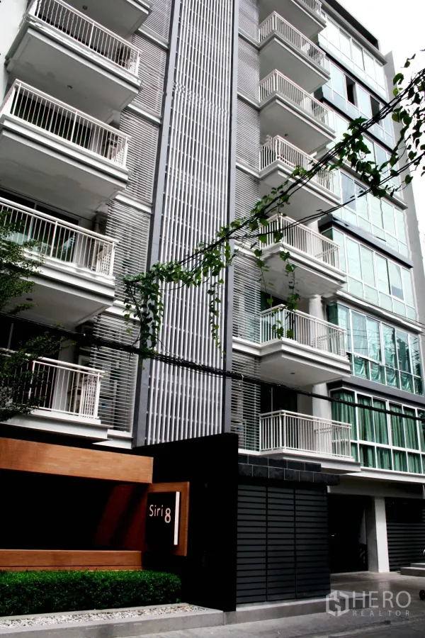 Condominium for rent in Khlong Toei, Bangkok - Contemporary condo façade with white balconies and the Siri 8 entrance sign.