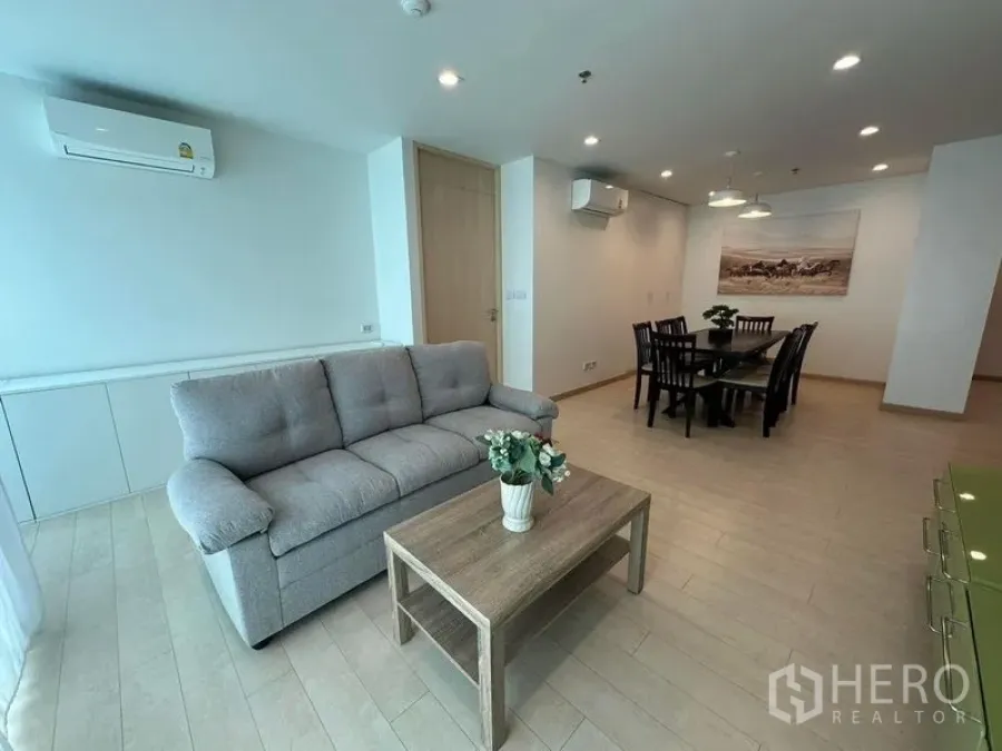 Condominium for rent or sale - Another angle of the bright living room with grey sofa, coffee table and adjoining dining area.