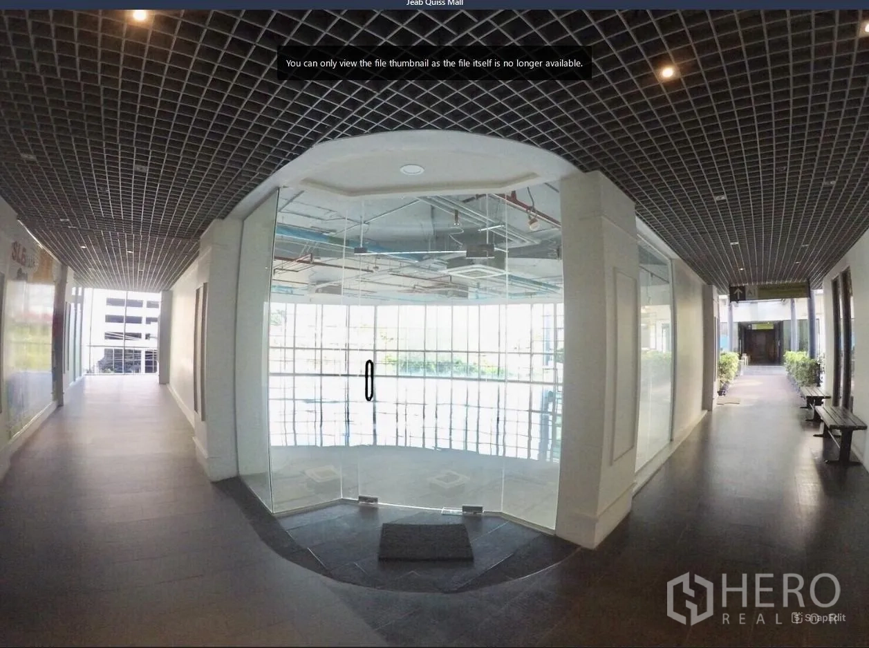 Office Space for rent in Khlong Toei, Bangkok - Commercial corridor with glass double doors opening into a curved-window office unit.