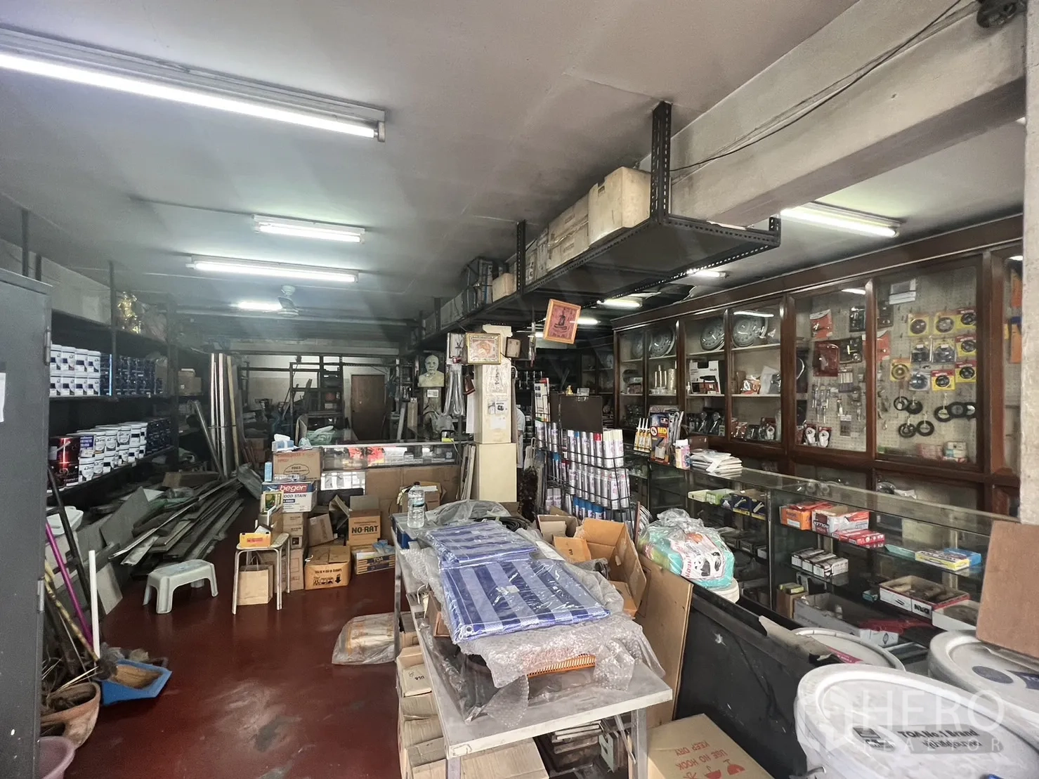 零售空间 出租在Watthana, Bangkok - 进深店铺，壁挂货架与玻璃橱柜，在条形灯下展示商品