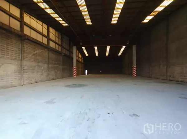 Factory for rent in Phra Pradaeng, Samut Prakan - Spacious factory interior with high ceiling, strip lighting and heavy‑duty concrete floor ideal for forklifts.