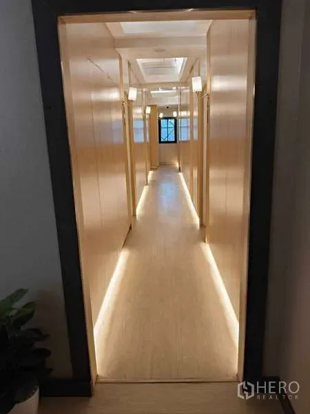 Retail Space for rent in Khlong Toei, Bangkok - Long corridor with warm lighting and wood panel walls leading to rooms.