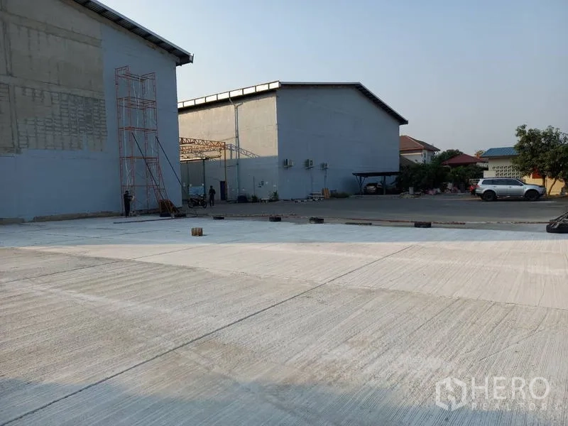 仓库 for rent in Mueang Pathum Thani, Pathum Thani - 仓库旁开阔的混凝土场地，适合卡车掉头与停车。