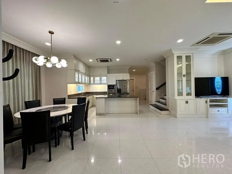 Detached House for rent or sale - Bright kitchen with island, upper cabinets and dining set beside the staircase.