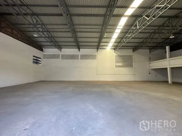 Warehouse for rent in Mueang Pathum Thani, Pathum Thani - Open-plan warehouse floor with tall ceiling, ventilation block windows and long strip lighting.