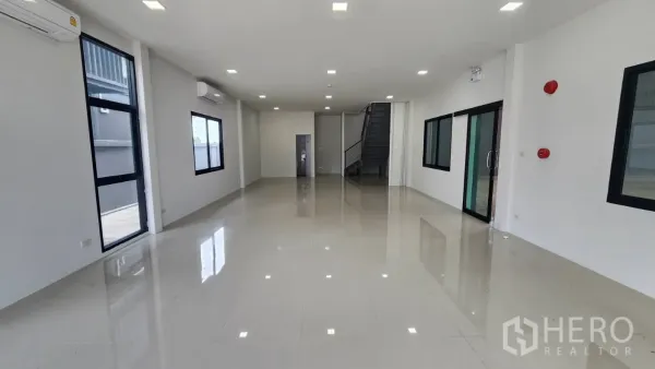 Factory for rent in Bang Bo, Samut Prakan - Bright ground-floor office with large windows, air-conditioning and stairs to the mezzanine.