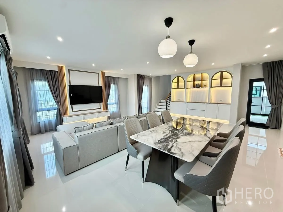 Detached House for rent in Bang Phli, Samut Prakan - Spacious open-plan lounge and dining area with arched backlit shelves and staircase.
