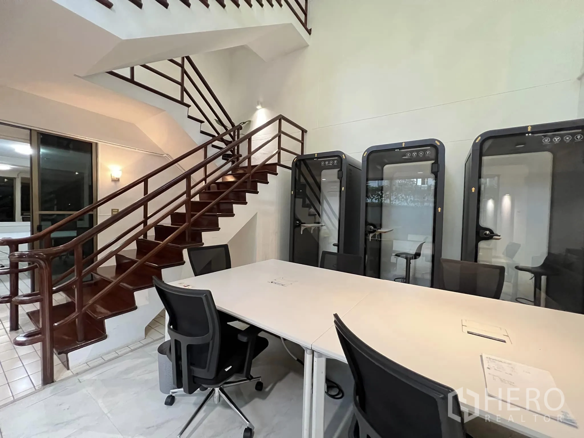 Townhouse for rent in Watthana, Bangkok - Stair hall with glossy wooden staircase and three private phone pods.