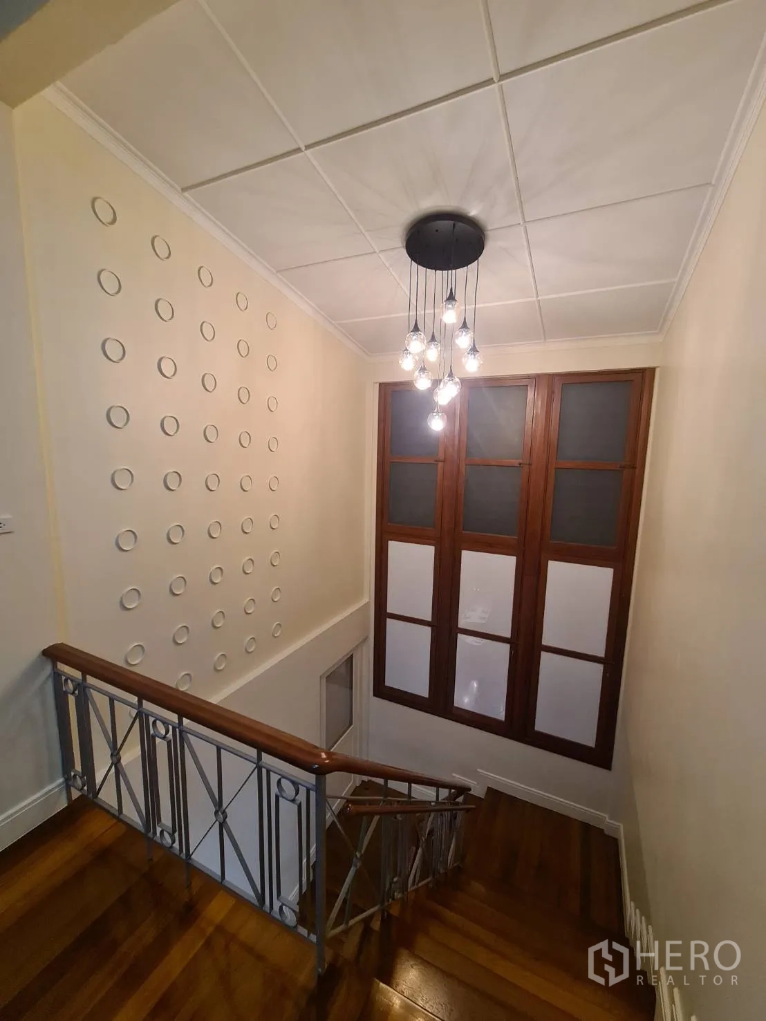 Detached House for rent in Khlong Toei, Bangkok - Staircase with designer chandelier and tall windows bringing in light.