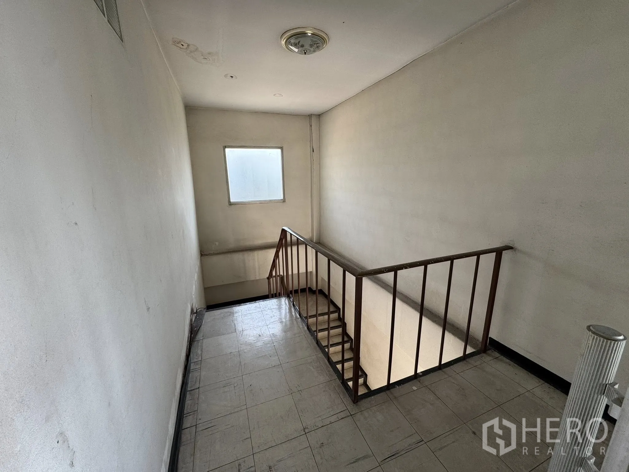 Warehouse for rent in Mueang Samut Sakhon, Samut Sakhon - Interior stairwell with metal handrail and a small window.