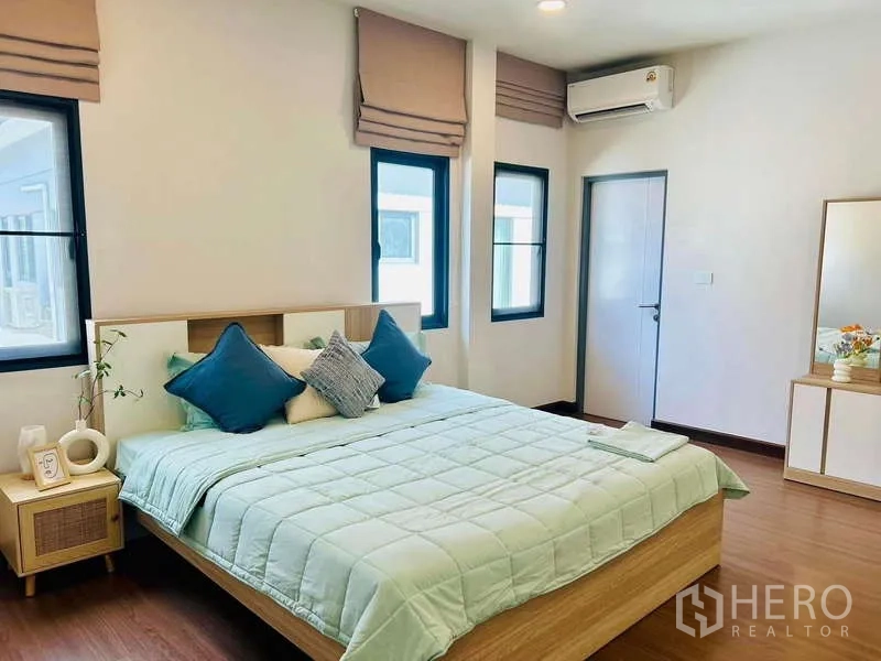 独立式住宅 出租在Bang Phli, Samut Prakan - 明亮的主卧，特大床、柔软床品、木地板、窗户与空调。