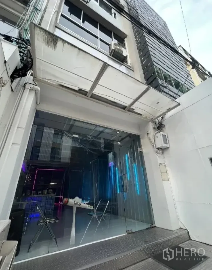 Shophouse for rent or sale in Watthana, Bangkok - Street-level view of shophouse entrance with glass storefront, canopy and ramp near BTS Phrom Phong.