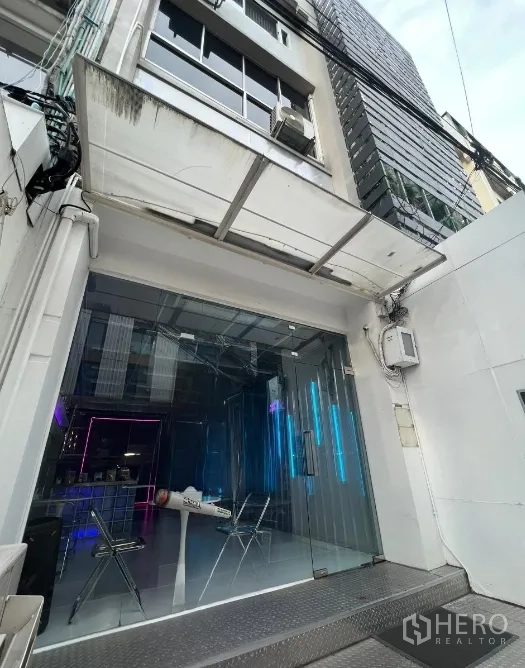 Shophouse for rent or sale in Watthana, Bangkok - Street-level view of shophouse entrance with glass storefront, canopy and ramp near BTS Phrom Phong.
