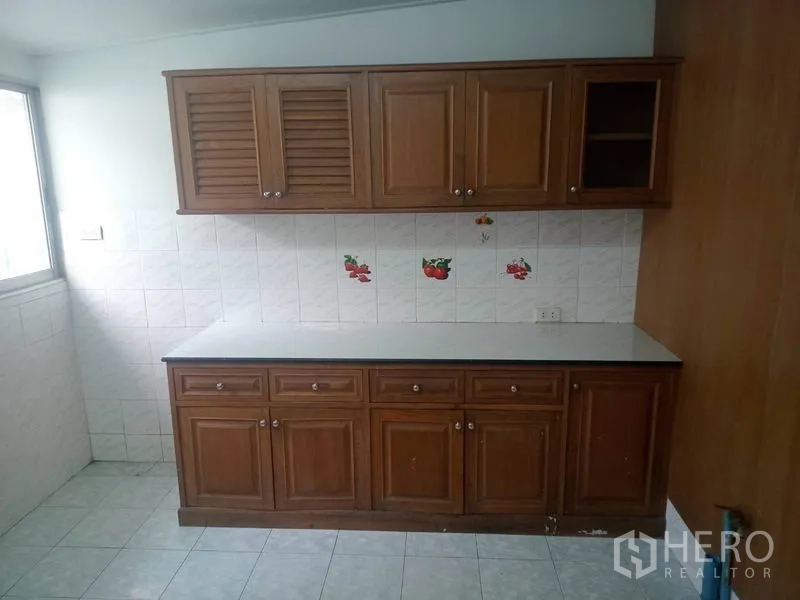 Detached House for rent in Sathon, Bangkok - Additional kitchen storage with upper and lower wooden cabinets and a tiled backsplash.