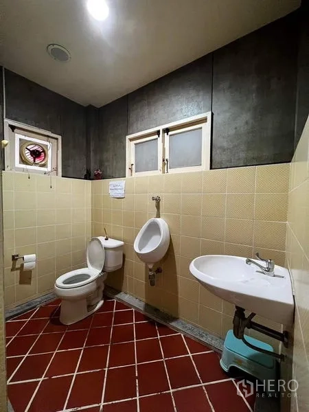 Townhouse for rent - Tiled bathroom with toilet, urinal and wall-mounted sink.
