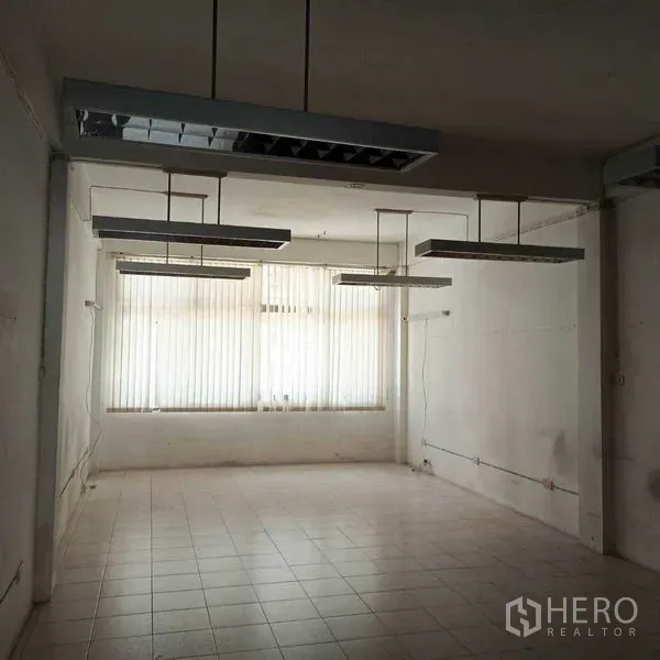 Shophouse for rent in Khlong Toei, Bangkok - Spacious workspace with suspended lights, tiled flooring and wide window.