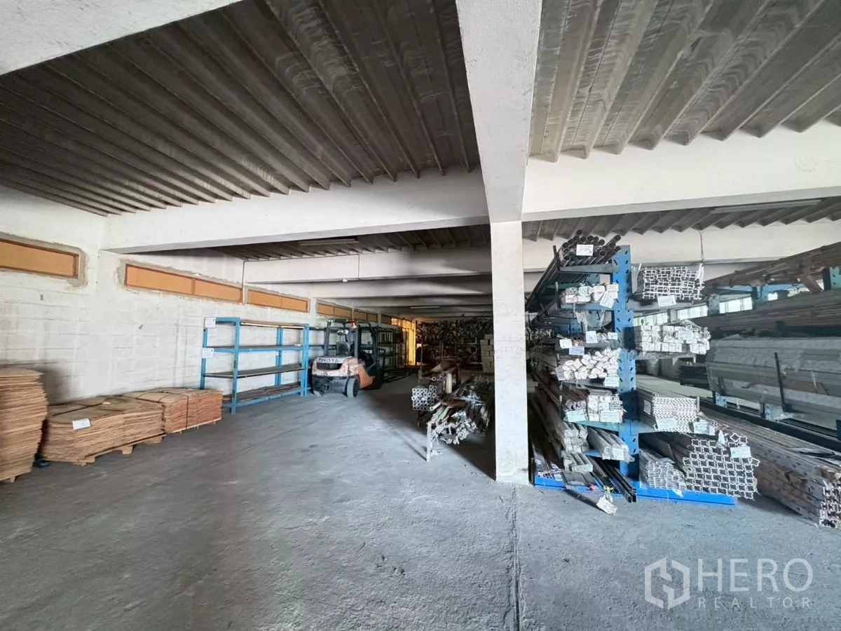 Factory for rent or sale in Bang Khun Thian, Bangkok - Warehouse aisle with forklift, racking and stacked materials.