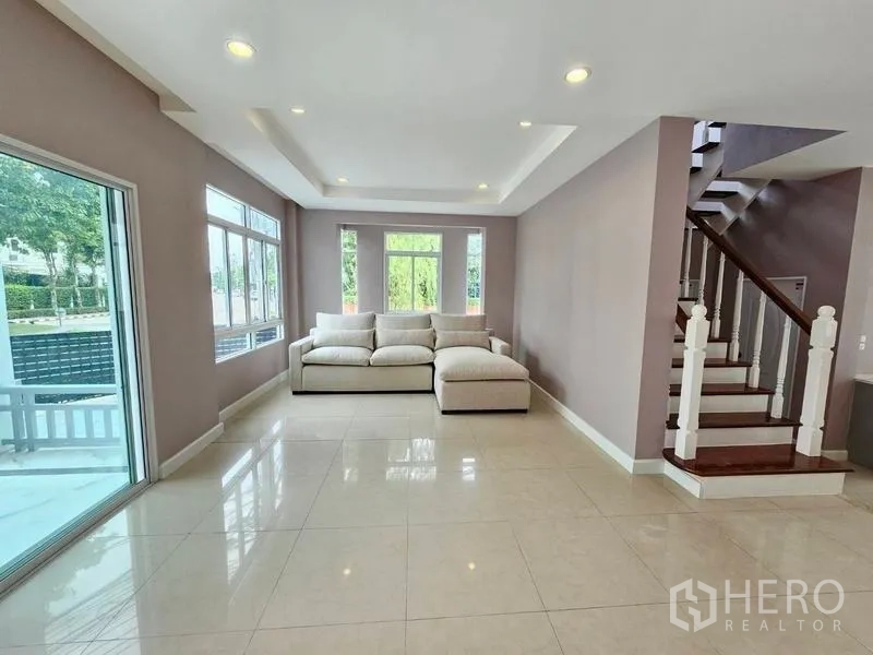 บ้าน ขายในPak Kret, Nonthaburi - ห้องนั่งเล่นโปร่งสว่าง มีหน้าต่างบานใหญ่ ประตูกระจกสไลด์ และบันไดไม้