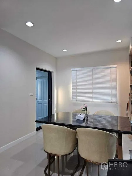 Detached House for sale in Khan Na Yao, Bangkok - Dining nook with marble-top table, four upholstered chairs and window blinds.