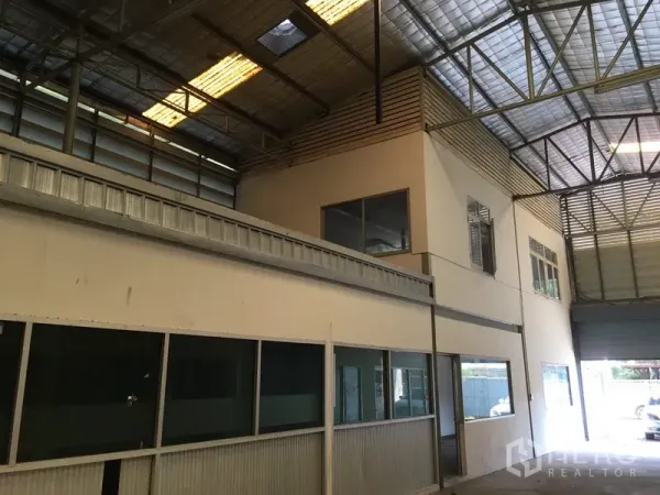 Warehouse for rent in Suan Luang, Bangkok - Double-height loading bay with upstairs office rooms and wide access door.