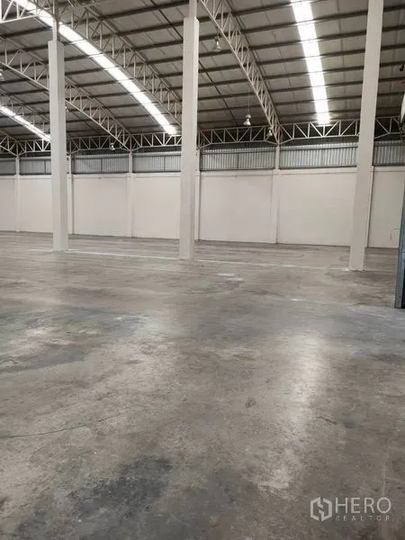 Warehouse for rent in Bang Pa-in, Phra Nakhon Si Ayutthaya - Storage hall with tall support columns, concrete floor and continuous strip lighting.