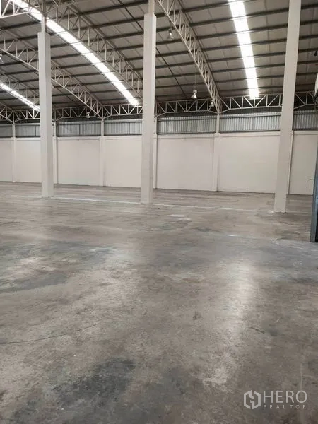 Warehouse for rent in Bang Pa-in, Phra Nakhon Si Ayutthaya - Storage hall with tall support columns, concrete floor and continuous strip lighting.