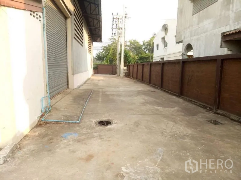 Factory for rent in Lat Lum Kaeo, Pathum Thani - Side driveway with roller door access and drainage points.