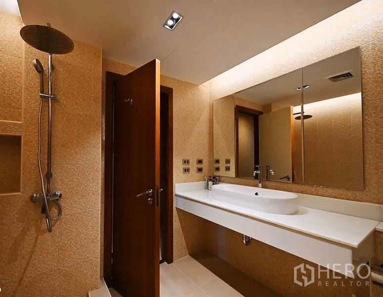Condominium for rent in Pathum Wan, Bangkok - Shower bathroom with rain shower, large mirror, and sleek white countertop.
