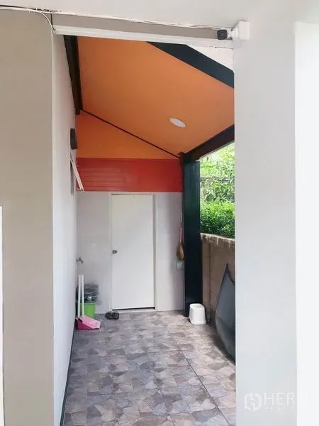 独立式住宅 出售在Suan Luang, Bangkok - 屋侧带顶多功能区，瓷砖地面与橙色天花。