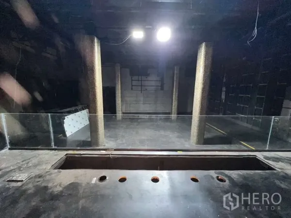 店屋 出租 - 深色开放大厅，圆形立柱与玻璃护栏。
