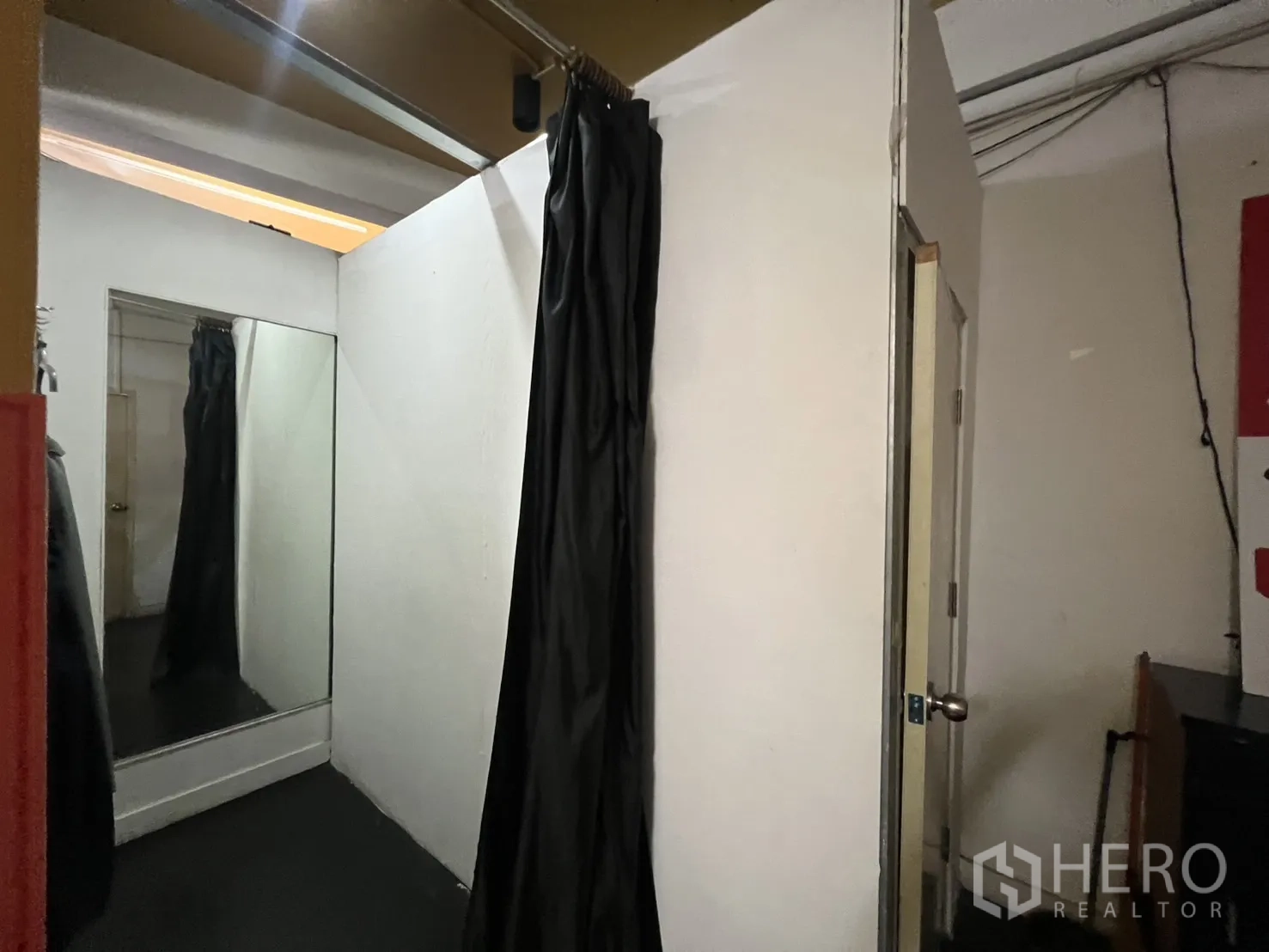 Shophouse for rent - Fitting room with full-height mirror and black curtain inside the shop.