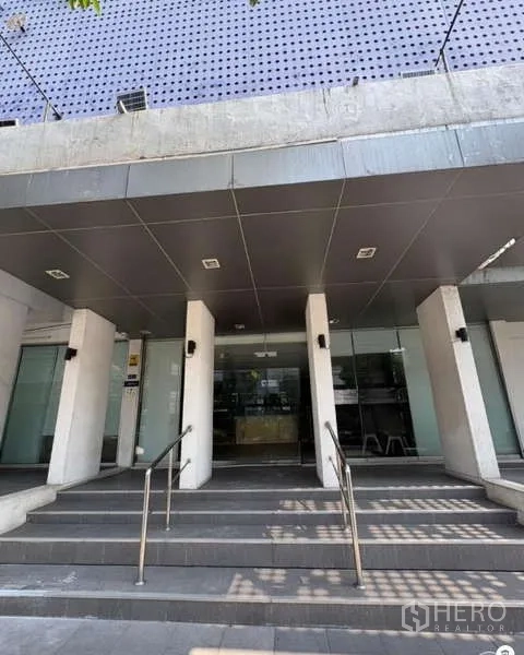 Office Space for rent in Khlong Toei, Bangkok - Main entrance of a three-storey office building with steps, pillars and glass doors in Khlong Toei.