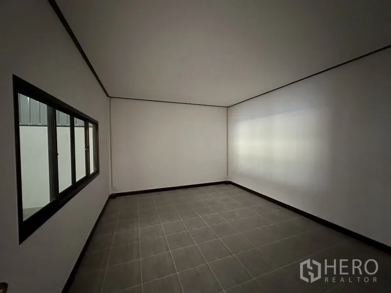 Warehouse for rent in Khlong Sam Wa, Bangkok - Simple tiled office room with a sliding window overlooking the warehouse floor.