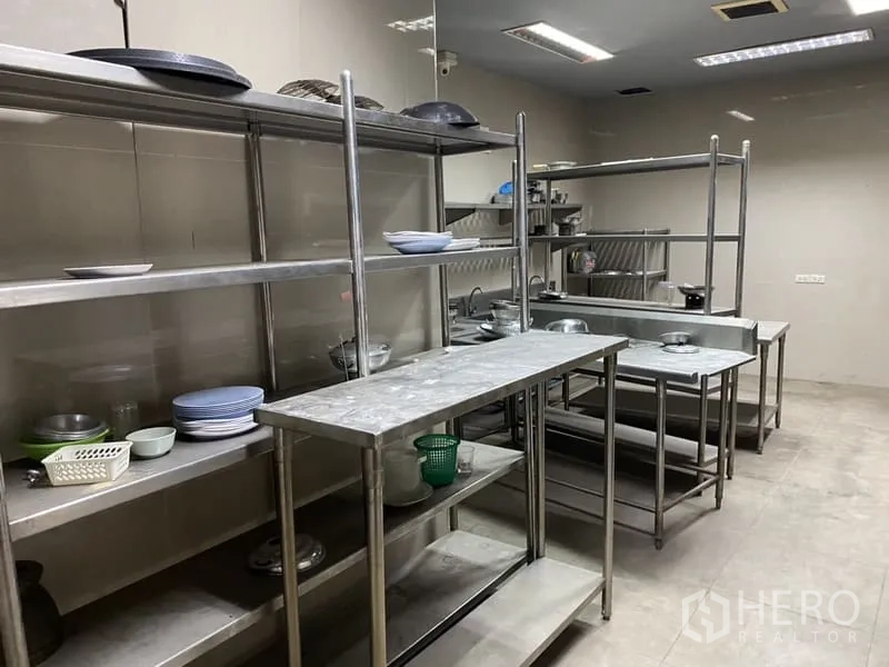 Showroom for rent in Lat Phrao, Bangkok - Commercial kitchen fitted with stainless-steel sinks, counters, and shelving.