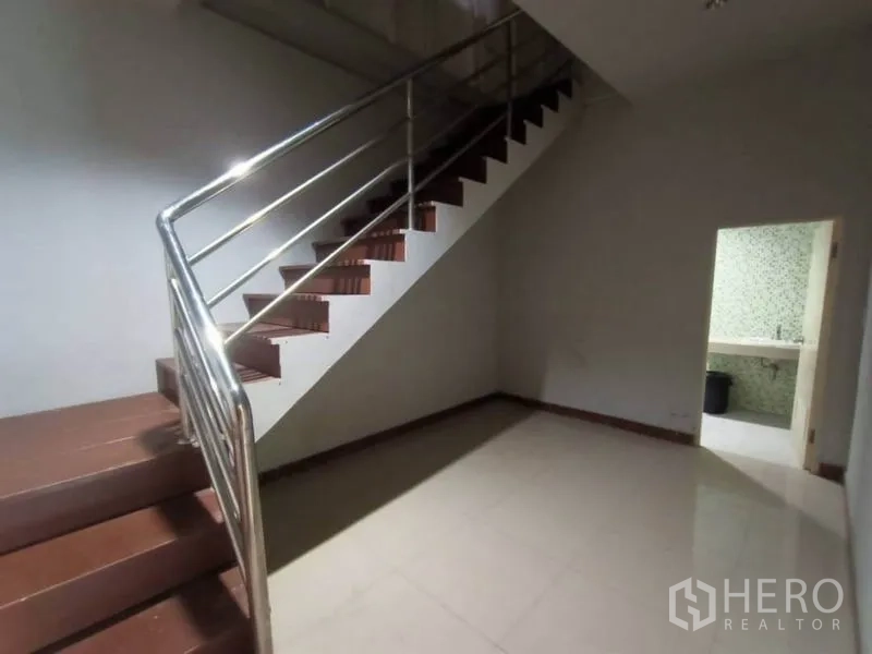Factory for rent or sale in Mueang Samut Sakhon, Samut Sakhon - Stairwell with stainless handrail next to a tiled restroom in the office area.