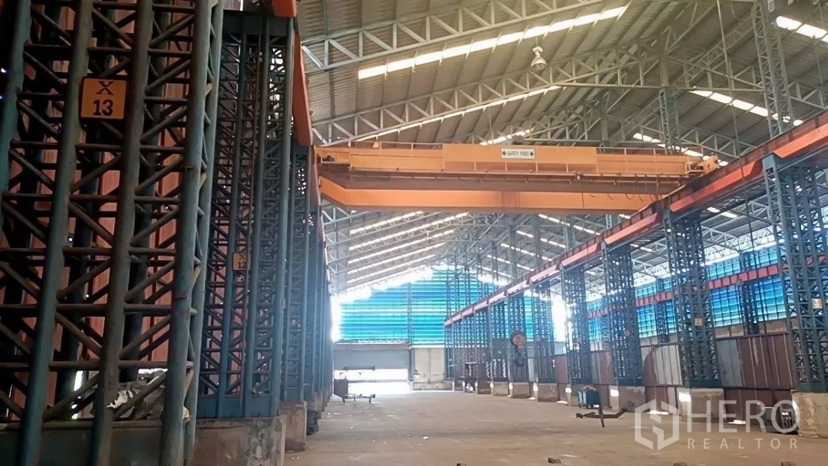 Warehouse for rent in Mueang Samut Sakhon, Samut Sakhon - Industrial warehouse interior featuring an overhead bridge crane, numbered steel columns, and a high clear-span roof.