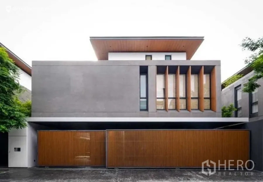 Detached House for sale in Huai Khwang, Bangkok - Modern facade with wood slat gates and vertical accent fins.