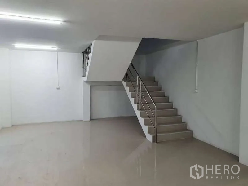 Warehouse for rent in Khlong Luang, Pathum Thani - Ground-floor office area with staircase and stainless handrail inside the warehouse building.