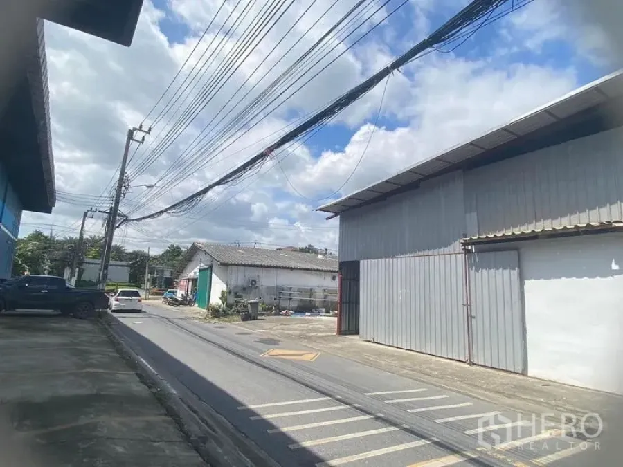 Warehouse for rent in Saphan Sung, Bangkok - Street-side view of the warehouse frontage with parking bay markings and vehicle access.