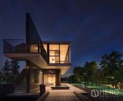 Detached House for rent in Prawet, Bangkok - Resident clubhouse illuminated at night beside landscaped grounds