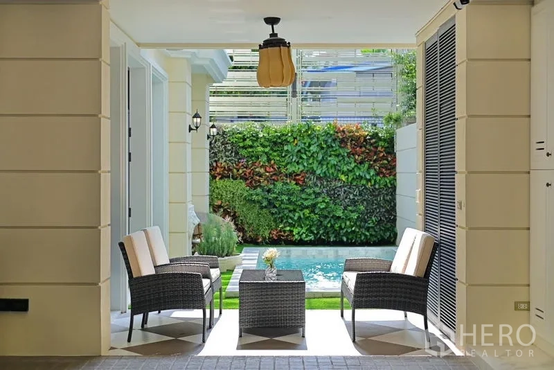 Detached House for rent or sale in Watthana, Bangkok - Covered patio seating area overlooking the plunge pool and vertical garden.