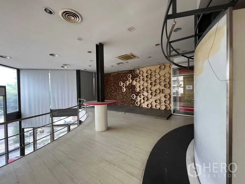 Retail Space for rent - Upper showroom level with honeycomb feature wall, large windows and balcony railing.