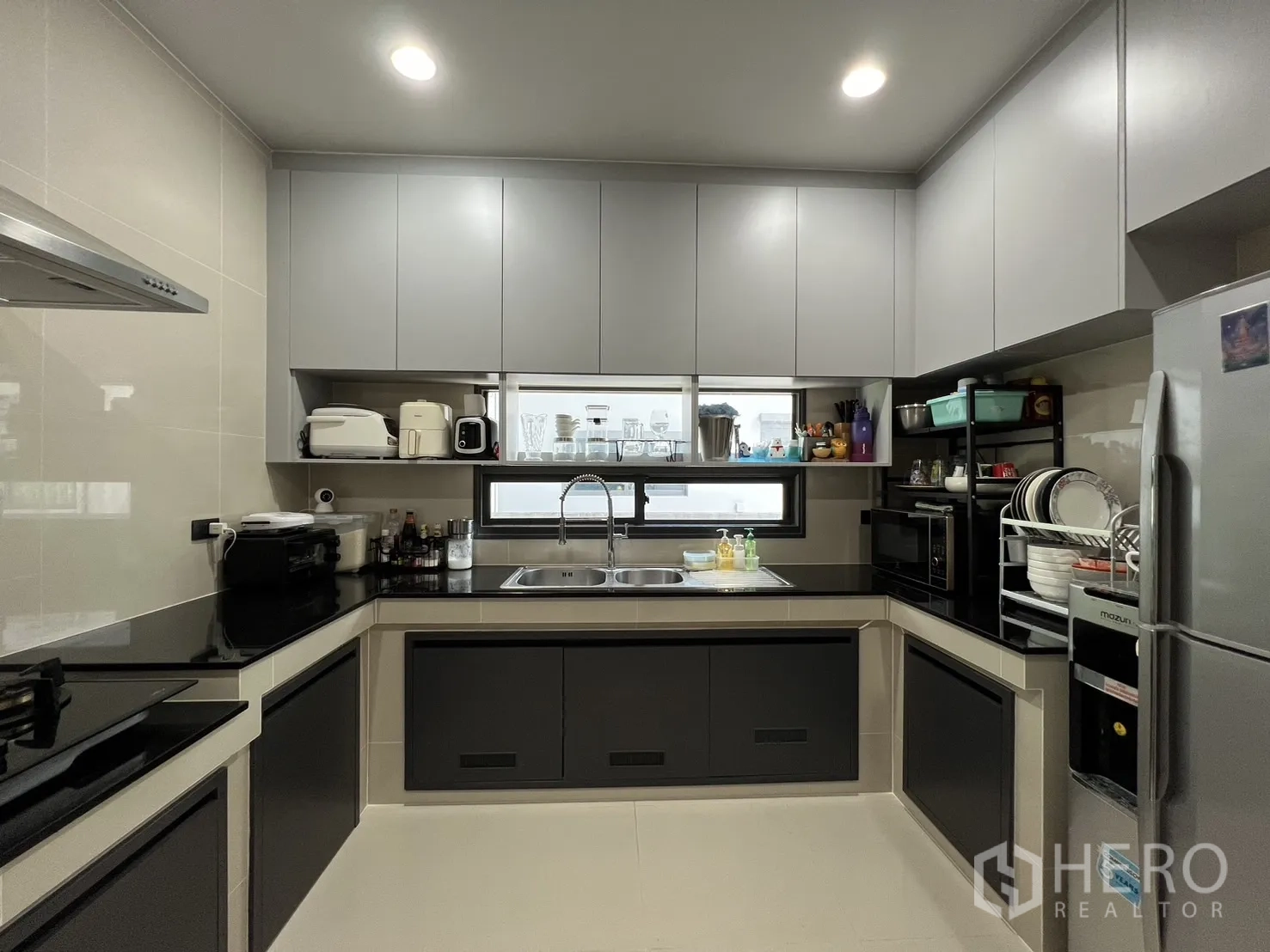 Detached House for rent or sale in Bang Kapi, Bangkok - Front view of kitchen with overhead cabinets and long window.