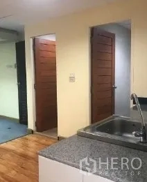 办公空间 出租在Bang Rak, Bangkok - 茶水间台面，前方两扇木门通往杂物间与卫生间。