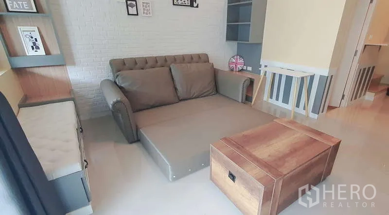 Detached House for rent in Bang Phli, Samut Prakan - Living room with sofa bed extended and wooden trunk-style coffee table.