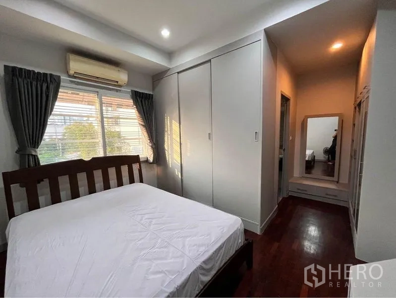 Townhouse for rent in Khlong Toei, Bangkok - Bright bedroom with large window, fitted closets and dressing nook with mirror.