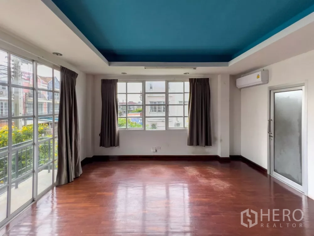 Home Office for rent in Lat Phrao, Bangkok - Bright corner room with wide windows and balcony access.
